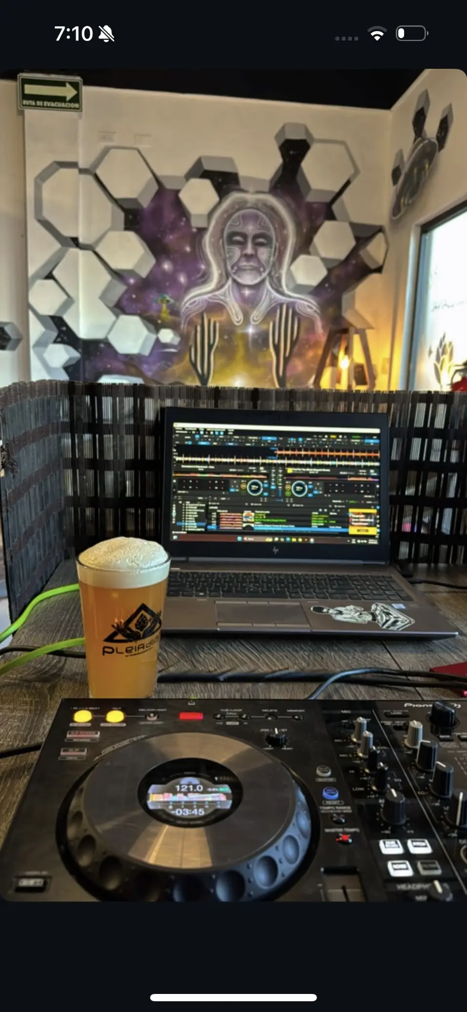 Setup de DJ en taproom Pleiadian con mural
